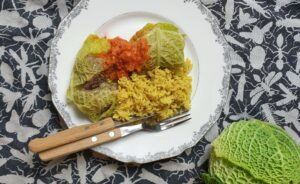 savooiekoolrolletjes gevuld met gehakt. geserveerd met gele rijst en een tomaten-paprikasausje