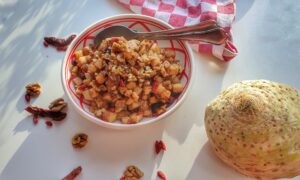 salade va ngebakken blokjes knolselderij met bessen, noten en zongedroogde tomaat