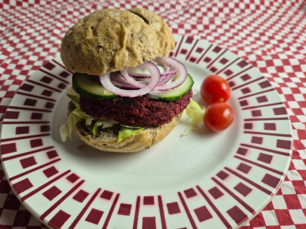 broodje met een burger van rode biet, met sla, komkommer en uiringen
