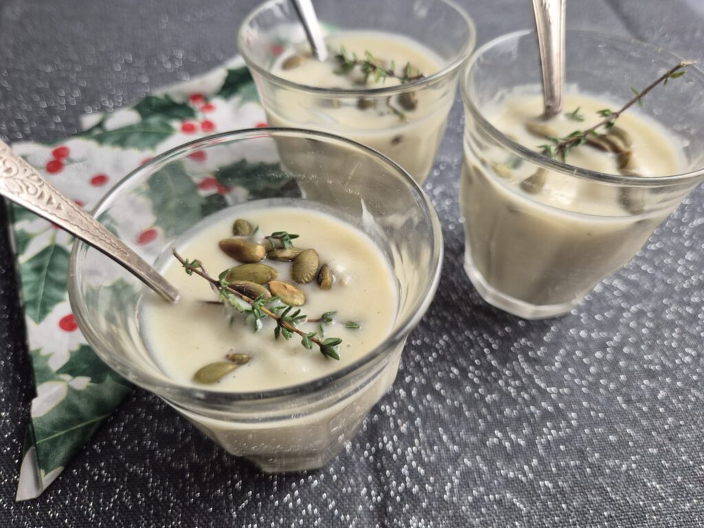 blanke bloemkoolsoep met tijm en pompoenpitjes, geserveerd in kleine glaasjes