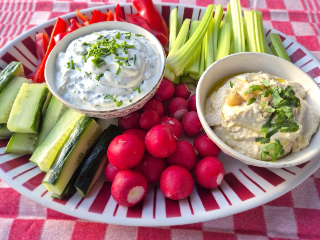 rauwe groenten met twee sausjes: radijs, paprika, komkommer en bleekselderij met een bakje hummus en een bakje kwarksaus