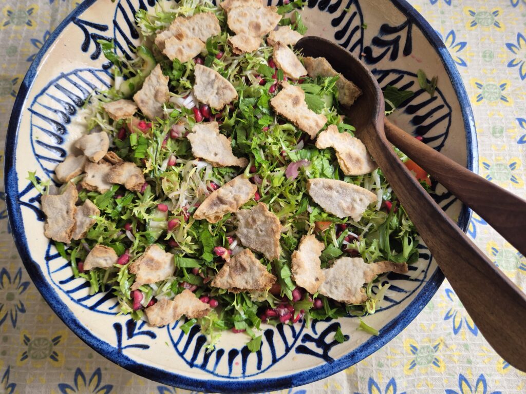 salade van krulandijvie met tomaat en komkommer en stukjes brood