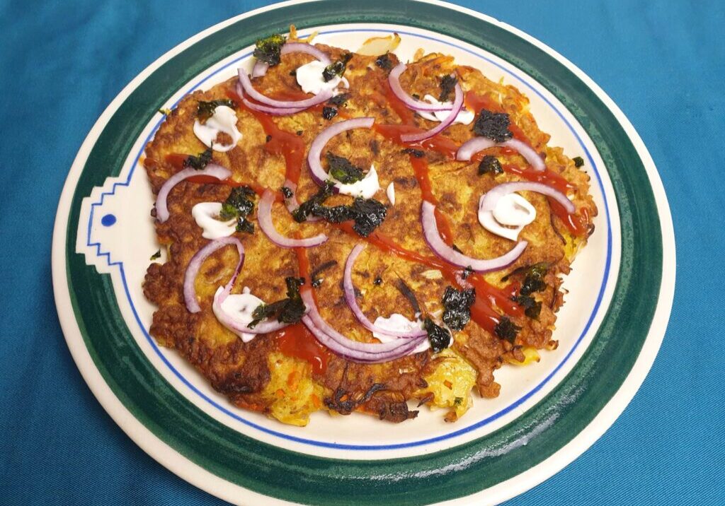 pannenkoek met witte kool, versierd met mayonaise, ketchup en zeewier
