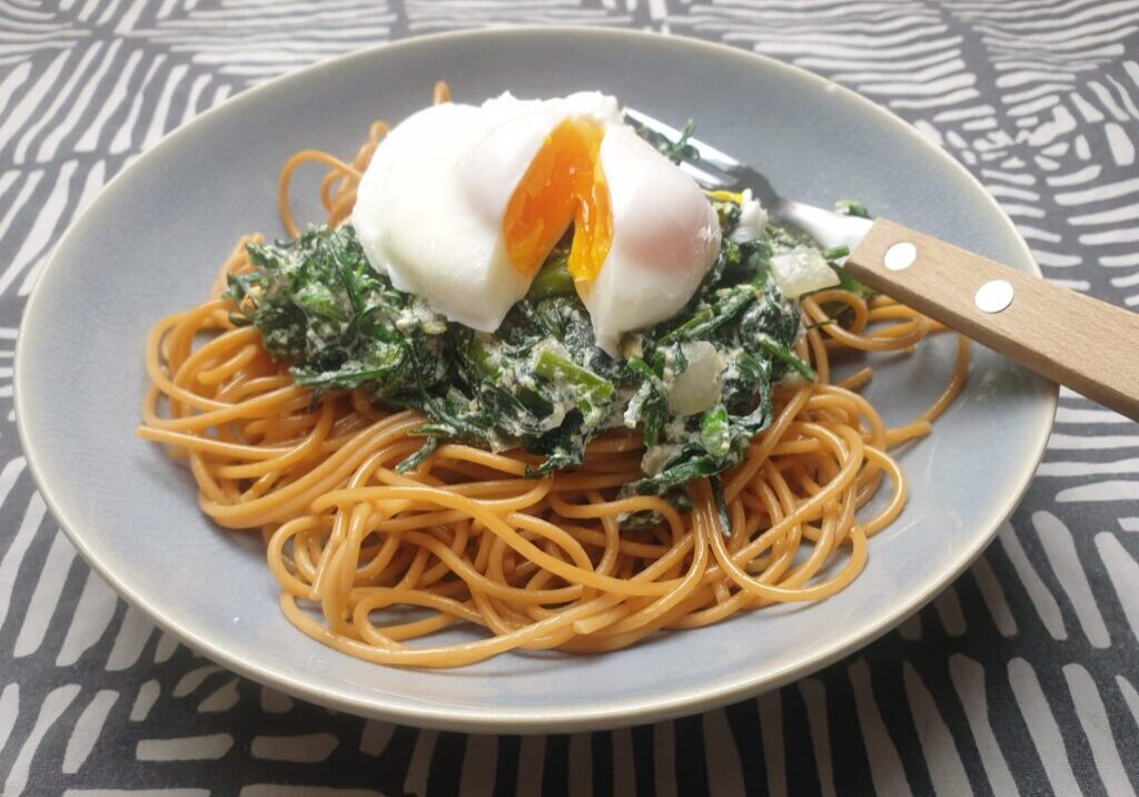 pasta met bladkool en roomsaus en een gepocheerd ei on top