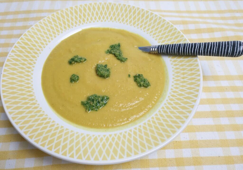 gele soep van knolselderij met kurkuma met groene klodders radijsbladpesto
