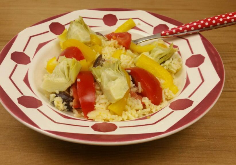 een salade van rijst, met paprika, tomaat en artisjokharten