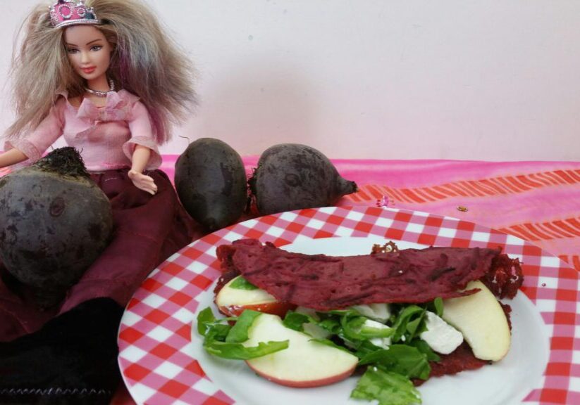 pannenkoek van bietjes, gevukd met ruciola, geitenkaas en appel. Barbie zit er blij naast, blij met zo'n roze pannenkoek