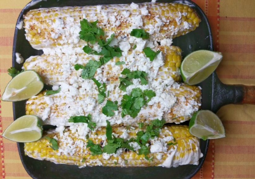 Mexicaanse maiskolven ‘Elotes’, met room, kaas, limoen en koriander