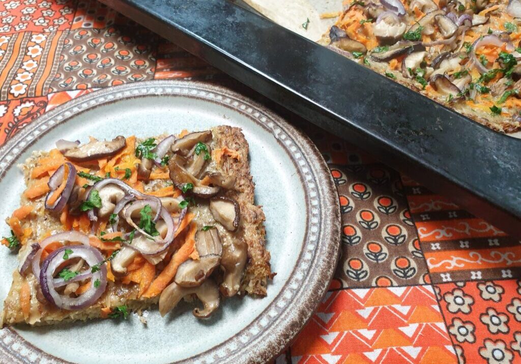 pizza van bloemkool, belegd met wortel en shitake