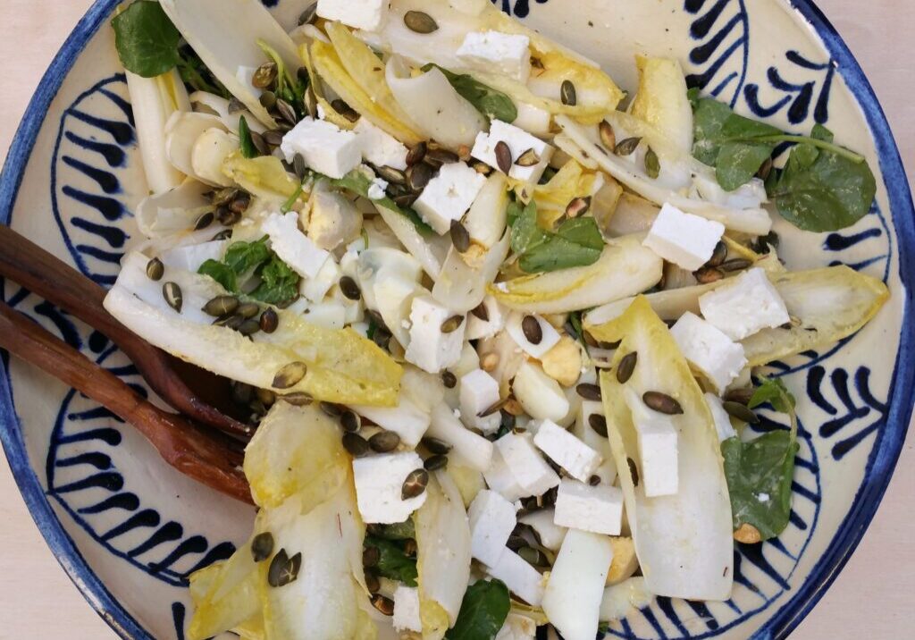 witlofsalade met ei, rucola en pompoenpitjes
