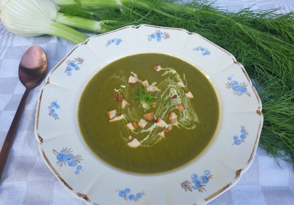 Een groene soep van het loof van venkel, gegarneerd met wat room en blokjes gebakken tofu. De venkel staat ook op de foto. 