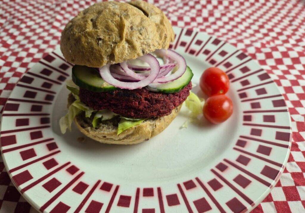 broodje met een burger van rode biet, met sla, komkommer en uiringen