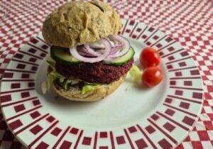 broodje met een burger van rode biet, met sla, komkommer en uiringen