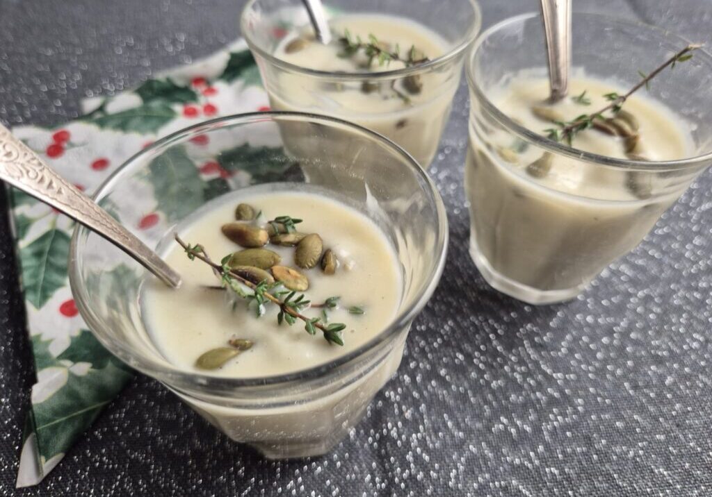 blanke bloemkoolsoep met tijm en pompoenpitjes, geserveerd in kleine glaasjes