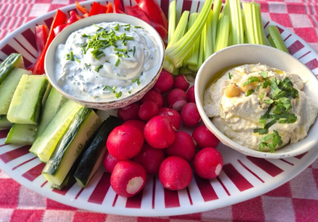 rauwe groenten met twee sausjes: radijs, paprika, komkommer en bleekselderij met een bakje hummus en een bakje kwarksaus