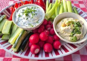 rauwe groenten met twee sausjes: radijs, paprika, komkommer en bleekselderij met een bakje hummus en een bakje kwarksaus