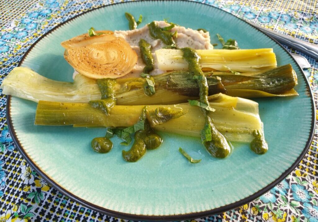 prei op een beetje bonenpuree, besprenkeld met groene prei saus en vereveineblaadjes