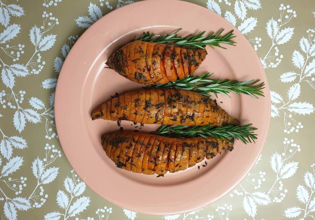 hasselback van bataat, versierd met takjes rozemarijn